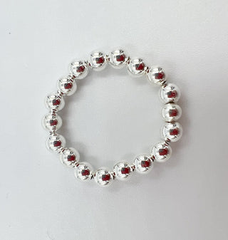 Silver beaded ring on a textured white background