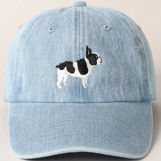 Light blue denim cap with a black and white dog illustration on a beige background