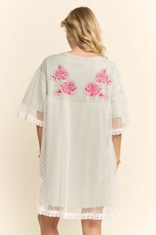 Women modelling a sage green mini dress with a lace overlay against a neutral photo backdrop.