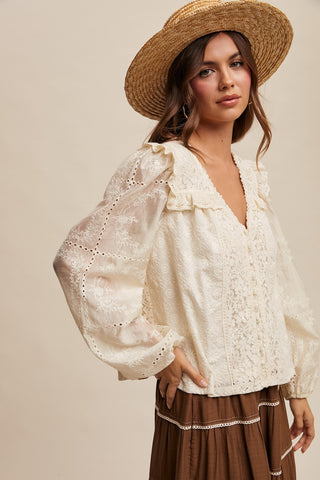 Woman wearing a white lace blouse and brown hat against a beige background
