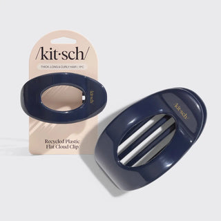 A glossy dark navy blue flat cloud clip shown next to its beige retail card packaging. The packaging features the brand name 'kit-sch' and text reading 'Thick, Long & Curly Hair | 1/2"'.