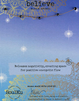 Necklace with black spinel stones on a blue card with text and branding