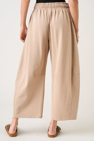 Beige wide-leg pants worn by a person on a white background