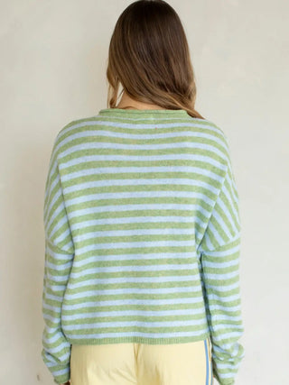 Person wearing a green and white striped sweater against a plain background