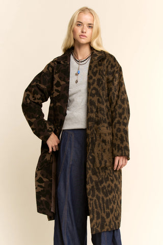 Person wearing a leopard print coat on a beige background