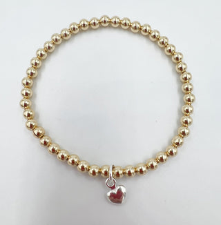 A gold-colored beaded bracelet with a sterling silver heart charm.