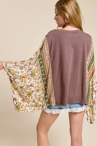 women wearing a a brown cowboy graphic tee with a floral boho sleeve. 
