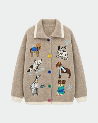 A khaki cardigan with embroidered dogs on it against a white background. 