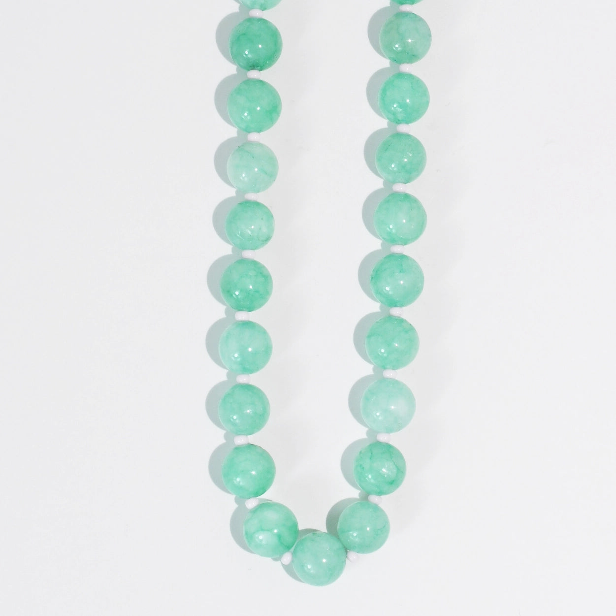A turquoise beaded necklace on a white background.