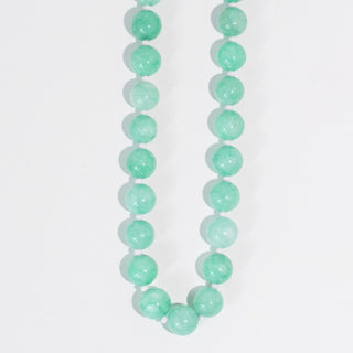 A turquoise beaded necklace on a white background.