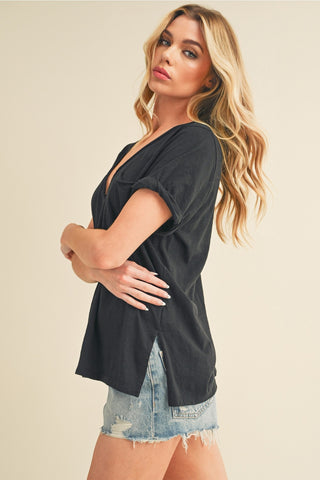 Woman wearing a black top and denim shorts on a beige background
