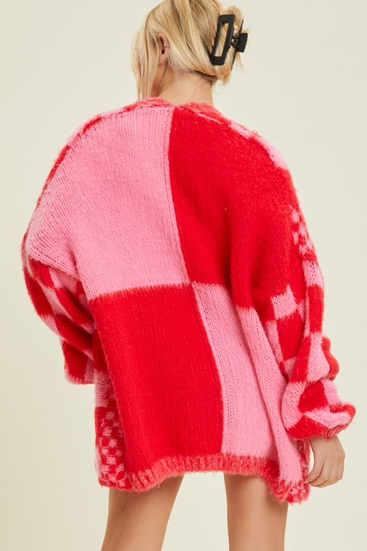Person wearing a red and pink checkered sweater on a beige background