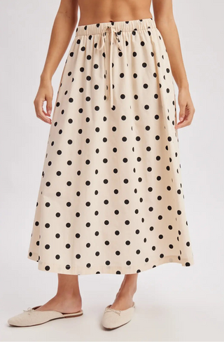Woman wearing a polka dot skirt on a plain background