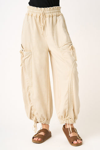 Beige baggy pants worn by a person on a white background