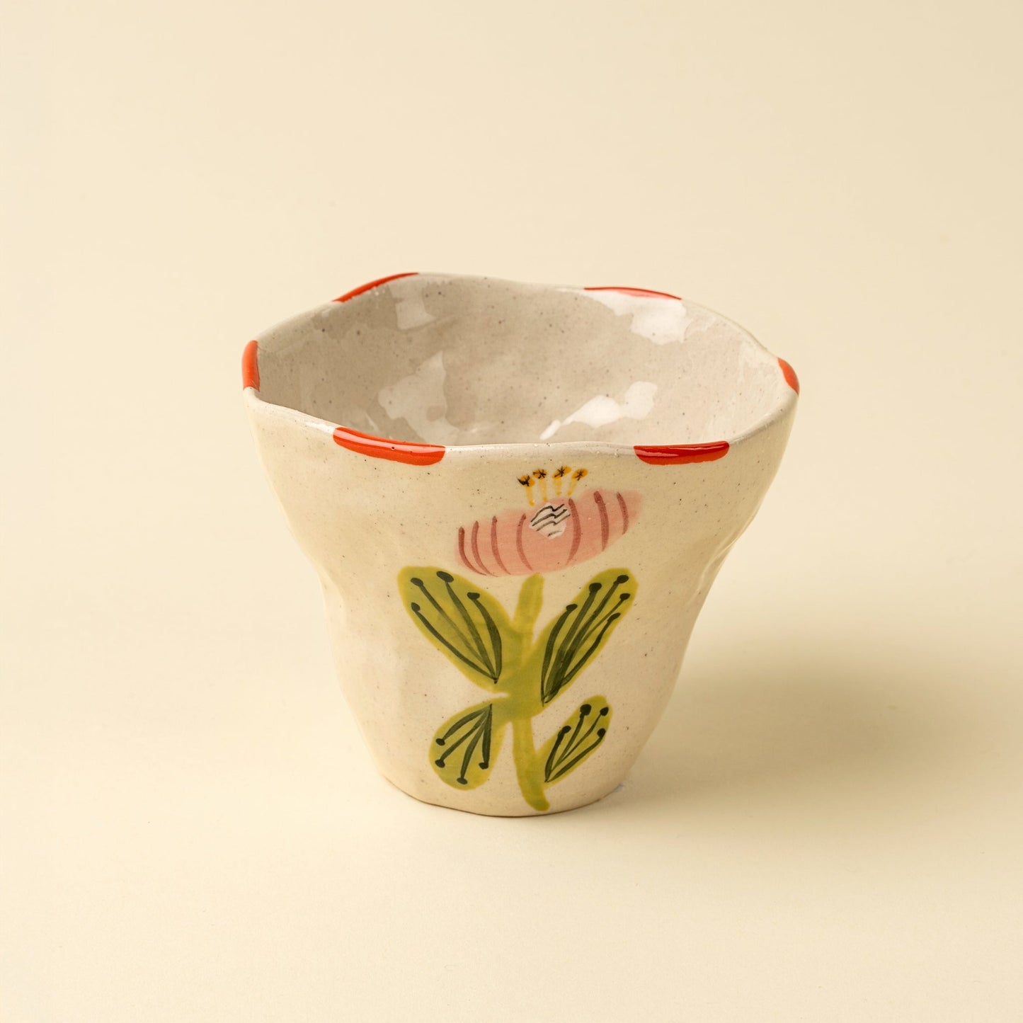 Ceramic cup with floral design on a beige background