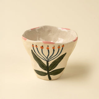 Ceramic cup with floral design on a beige background