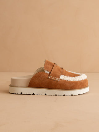 Brown slip-on shoe with white sole on a beige background