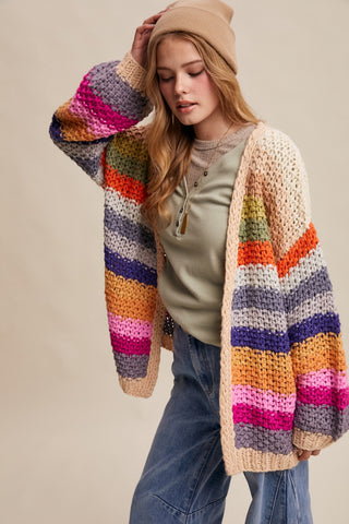 Woman wearing a colorful striped cardigan on a beige background