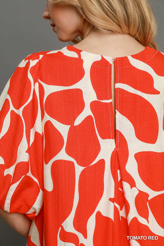 Women wearing a read dress by the pool.