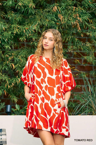 Women wearing a read dress by the pool.