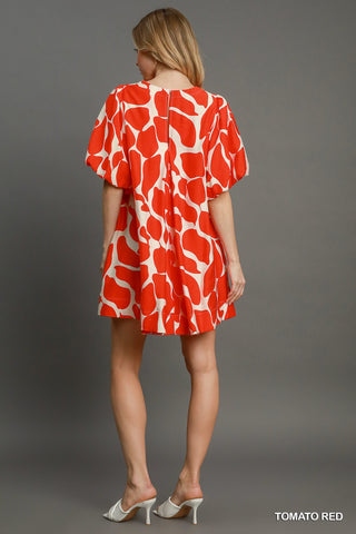 Women wearing a read dress by the pool.