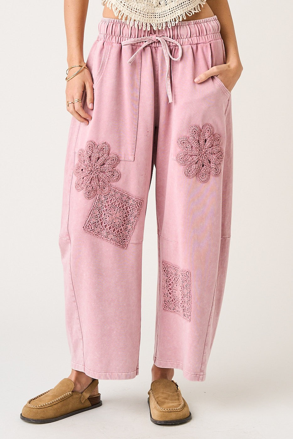 Pink pants with floral embroidery on a white background