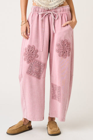 Pink pants with floral embroidery on a white background