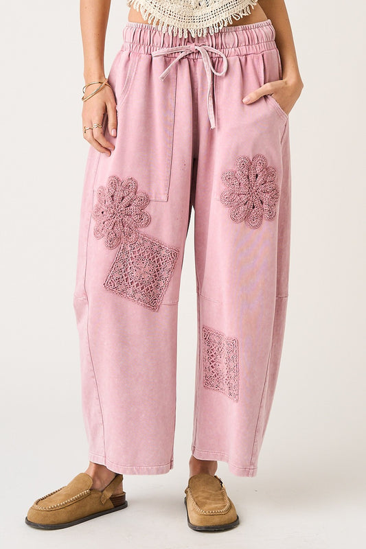 Pink pants with floral embroidery on a white background
