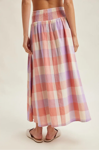 Person wearing a plaid skirt on a plain background