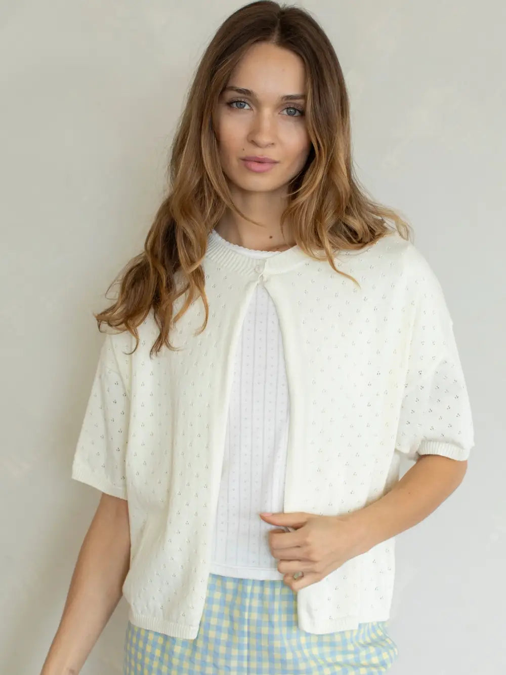 Woman wearing a white blouse with a light background