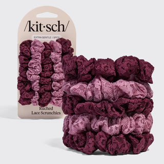 A set of five Kit-Sch ruched lace scrunchies in a vertical color gradient from light pink to deep burgundy, shown with the retail packaging on a light gray background.