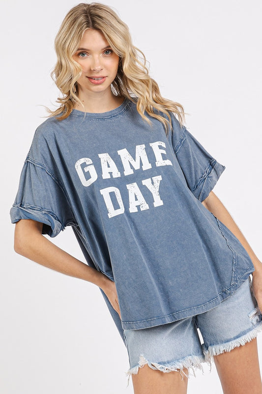 Woman wearing a blue 'GAME DAY' t-shirt and denim shorts on a white background