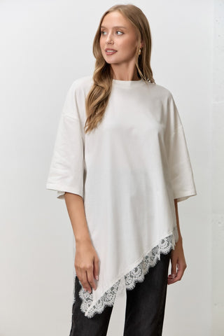 Women wearing a white t shirt with Lace Trim against a neutral background. 