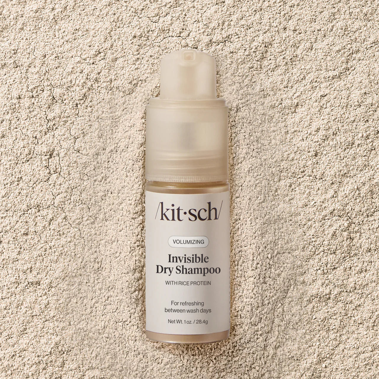 Kit-sch Invisible Dry Shampoo bottle on a textured beige background