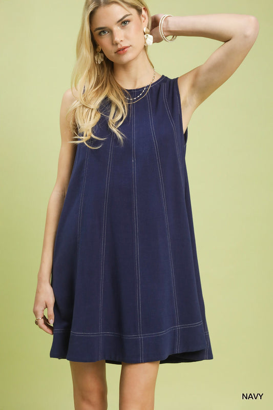 Woman wearing a navy dress on a light green background