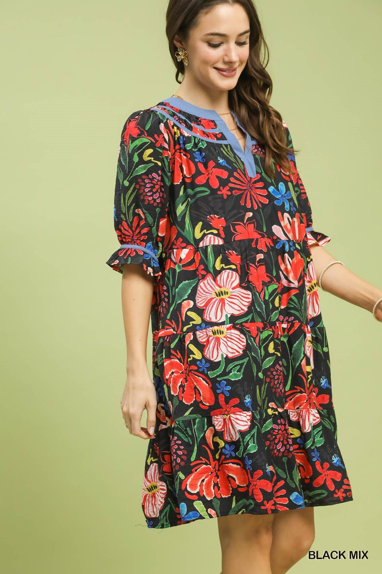 Woman wearing a colorful floral dress on a light green background