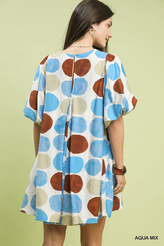 Woman wearing a polka dot dress with a plain background