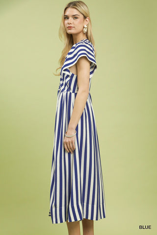 Woman wearing a blue and white striped dress on a green background