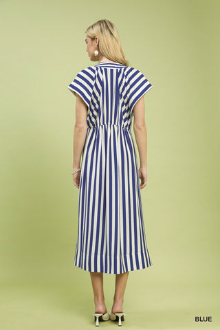Woman wearing a blue and white striped dress on a light green background