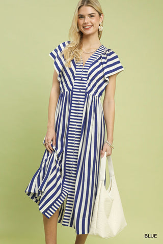Woman wearing a blue and white striped dress against a light green background