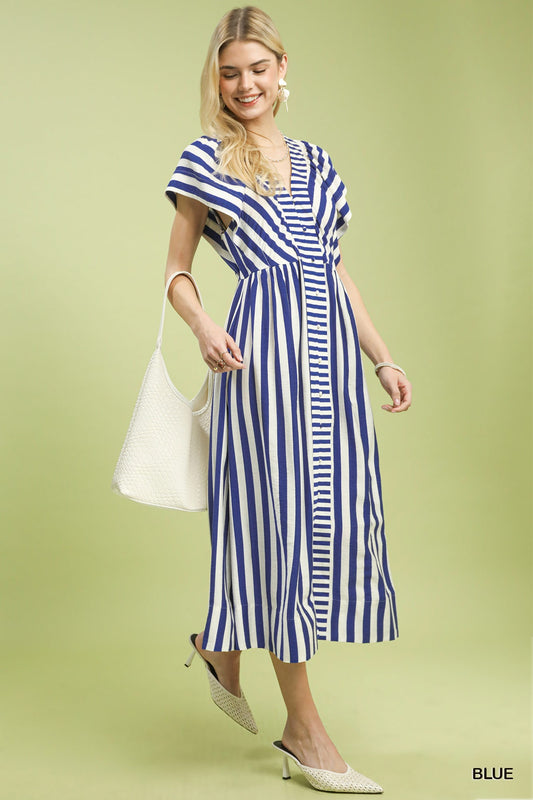 Woman wearing a blue and white striped dress on a light green background