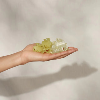 Hand holding a clear plastic object against a plain background