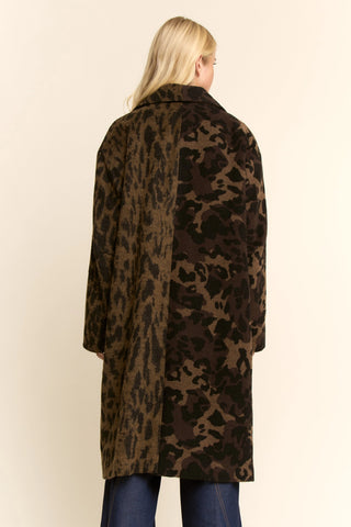 Person wearing a leopard print coat on a beige background