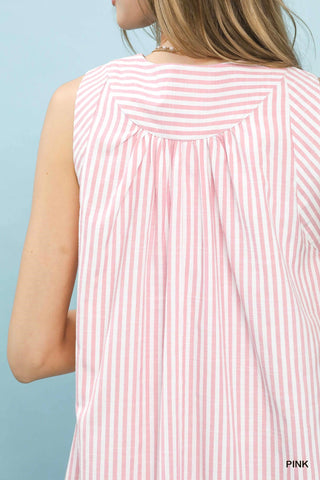 Close-up of a person wearing a pink and white striped sleeveless top against a light blue background.