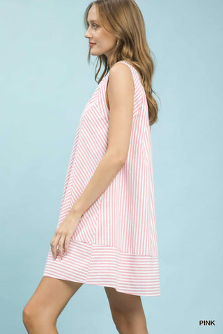 Woman wearing a pink and white striped dress against a light blue background