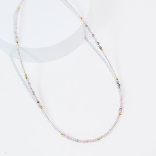 A dainty and simple pink and grey beaded necklace. 