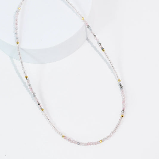 A dainty and simple pink and grey beaded necklace. 