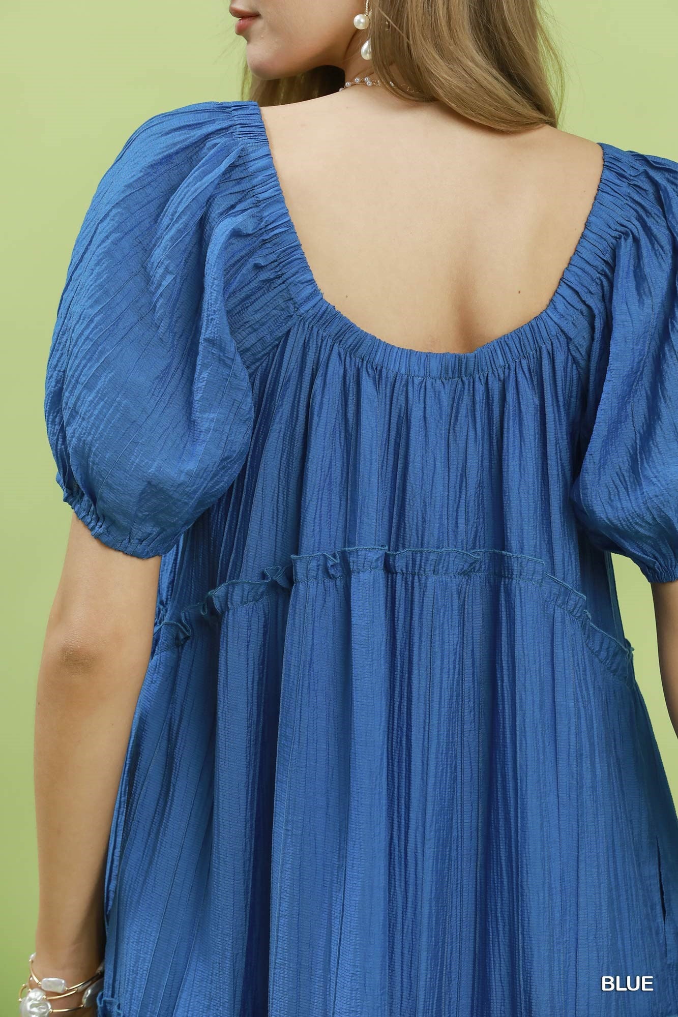 Blue dress with puffed sleeves on a green background