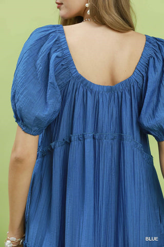 Blue dress with puffed sleeves on a green background