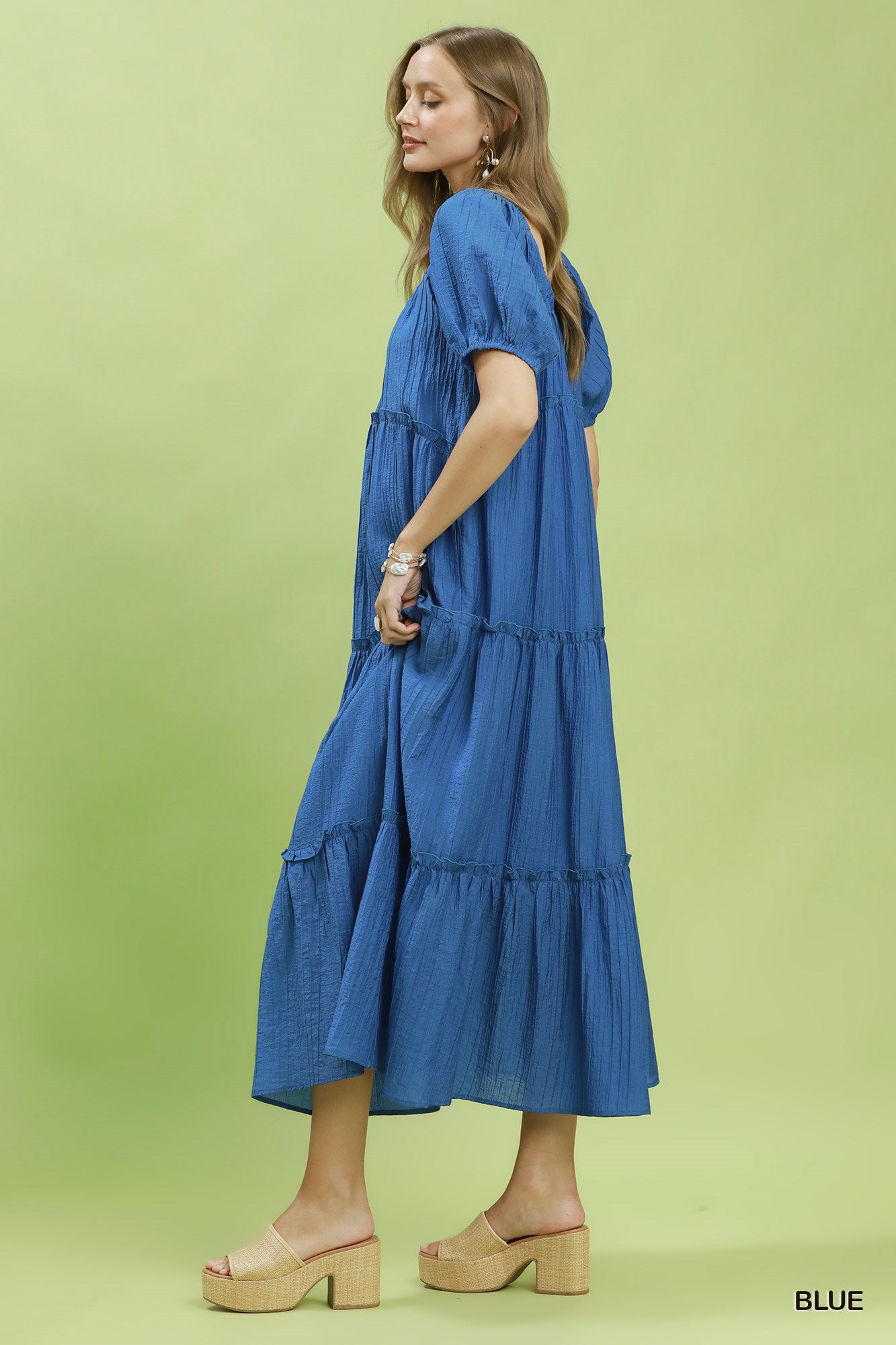 Woman wearing a blue dress on a green background
